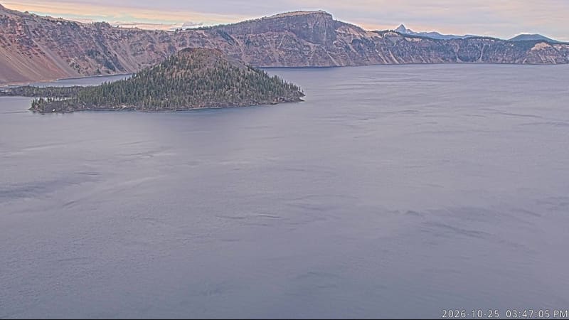 Crater Lake’s deep blue water fills the view, with Wizard Island and the far caldera walls beyond.